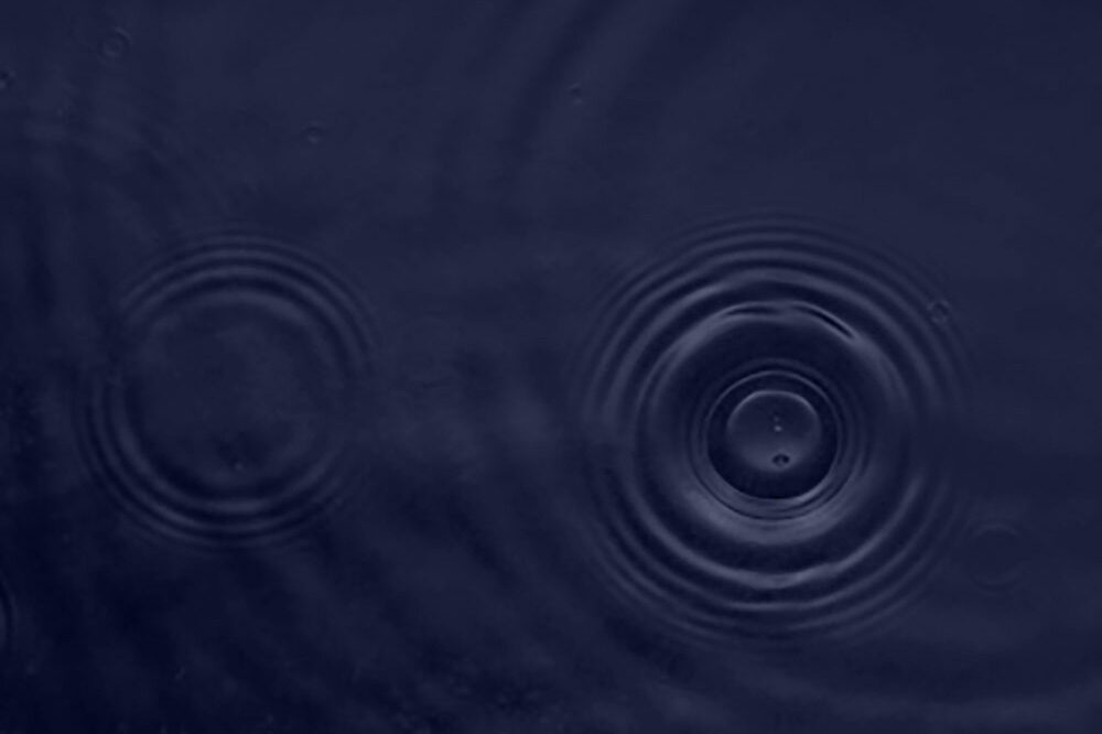 Close up of the surface of some water, with two ripples in the left side.