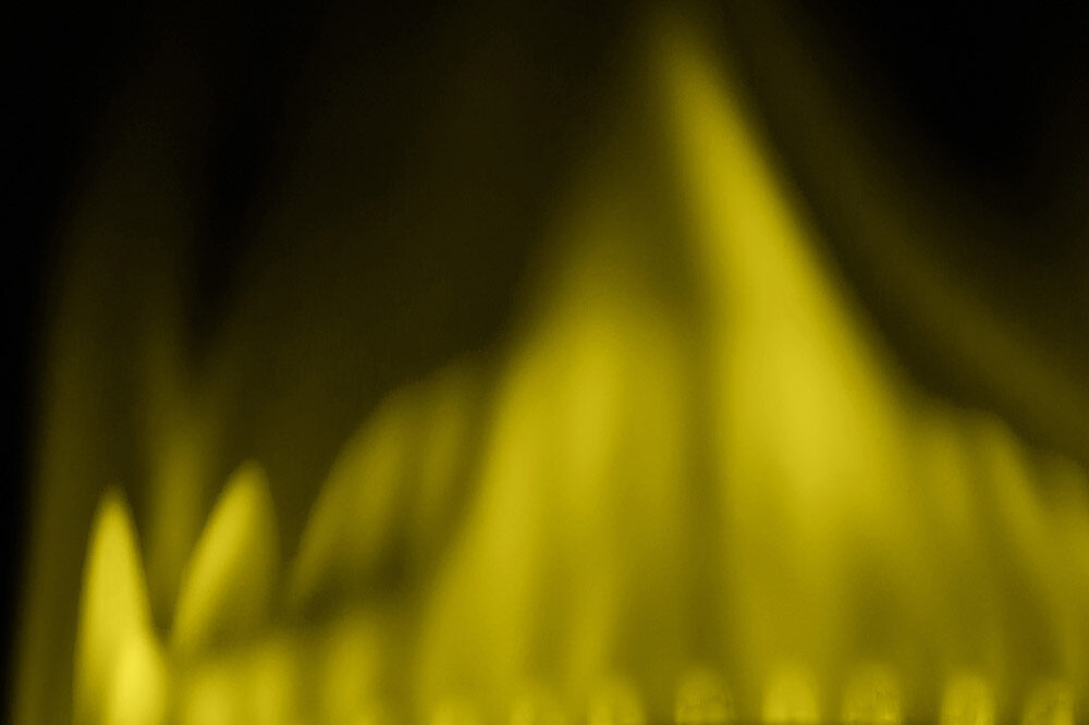 Blurred image of a yellow flame, against a black background.